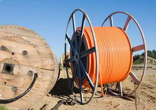 A reel of orange fibre conduit on a job site